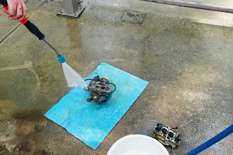 De carburateur wordt schoongespoten.