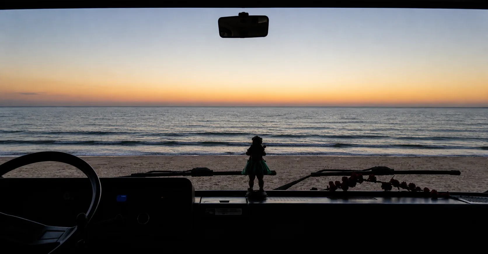 Uitzicht door de voorruit van de camper bij zonsondergang — slimme automatisering onderweg