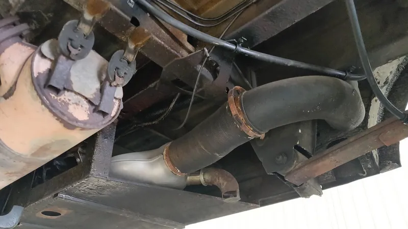 De oude Eberspächer BA6-benzinekachel onder de bus, met zijn uitlaat en warmeluchtslang